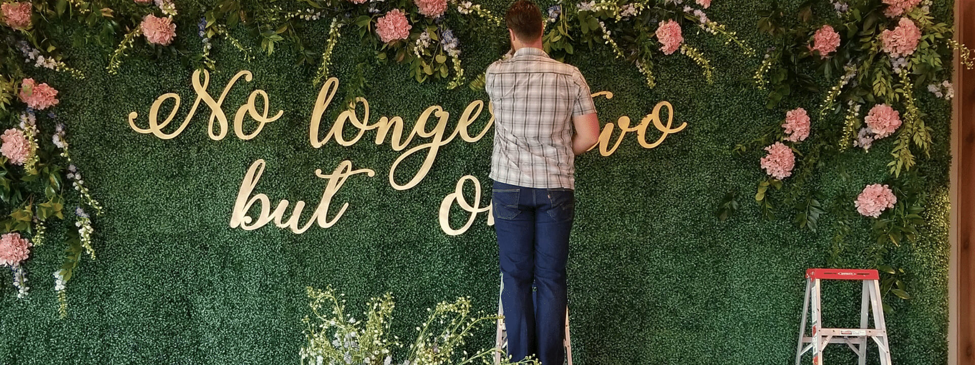 designer adding message to floral wall display